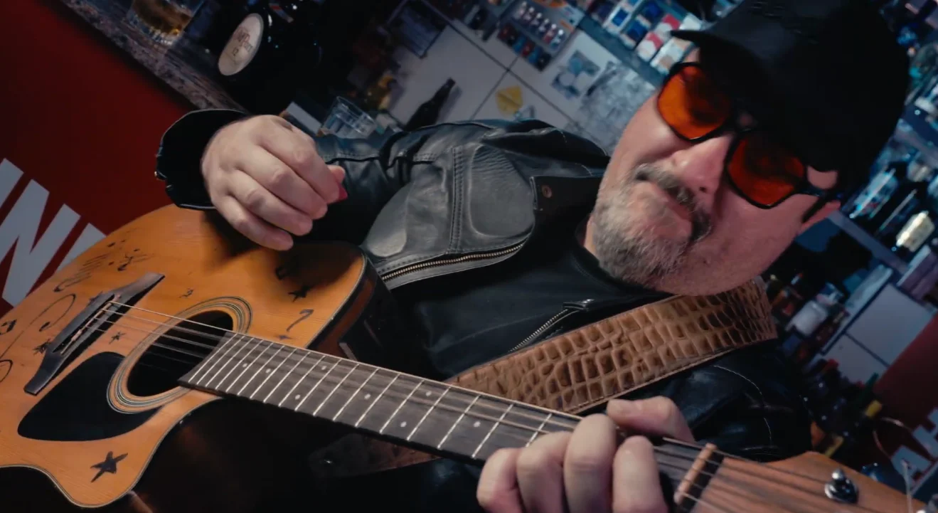 Músico com violão em uma cena de videoclipe